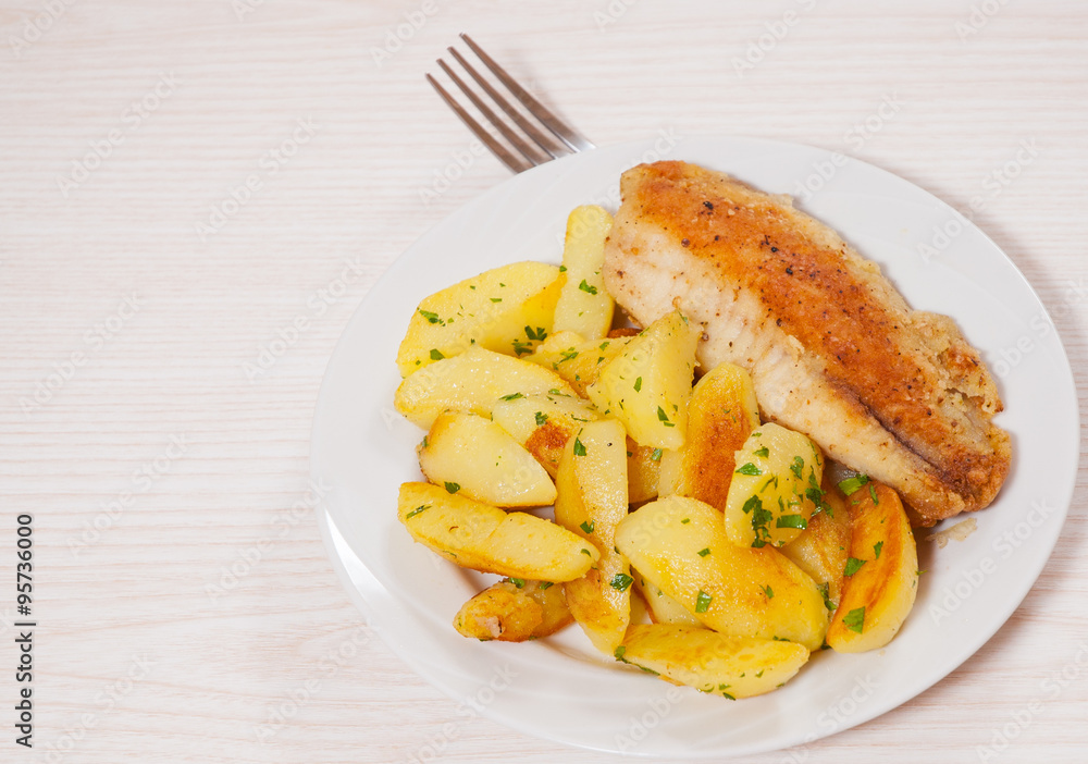 Fried fish fillet and potatoes in a plate Fried fish fillet and potatoes in a plate