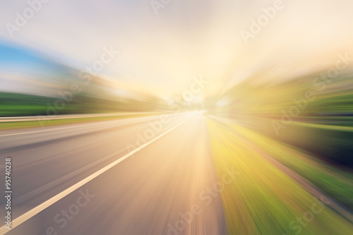 Empty asphalt road in motion blur and sunlight with vintage tone
