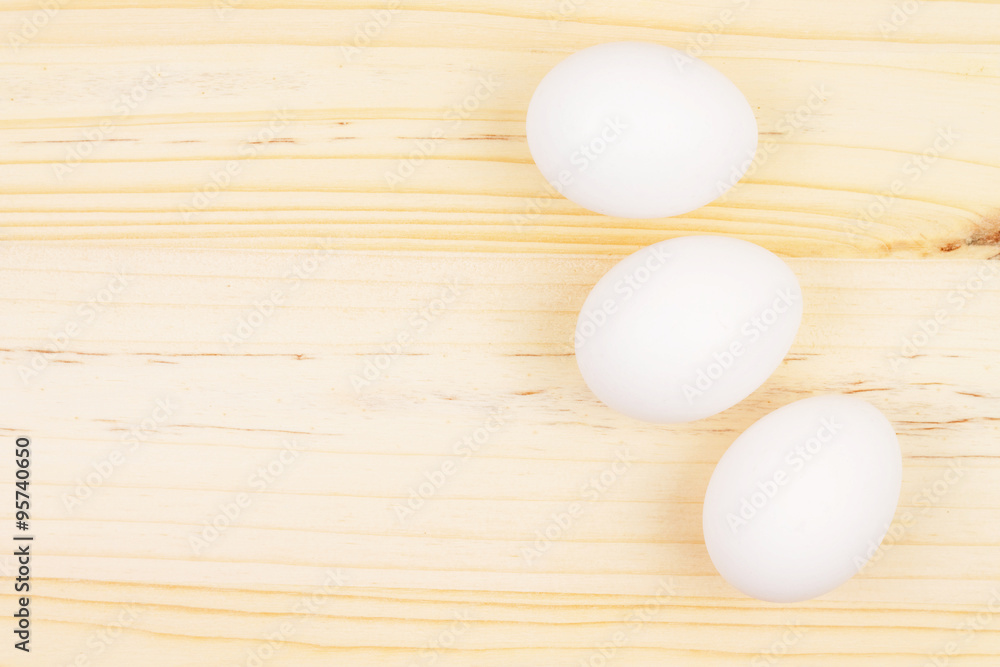 Three White Eggs on Wooden Chopping Board Three White Eggs on Wooden Chopping Board
