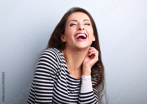 Laughing young casual woman with wide open mouth and closed eyes