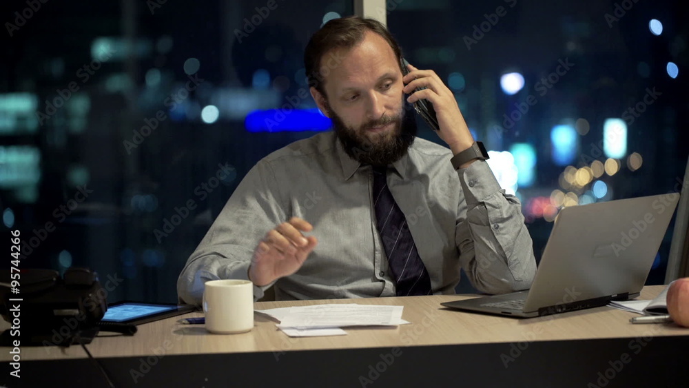 Businessman with tablet document, talking on cellphone and drinking coffee in office
Businessman with tablet document, talking on cellphone and drinking coffee in office