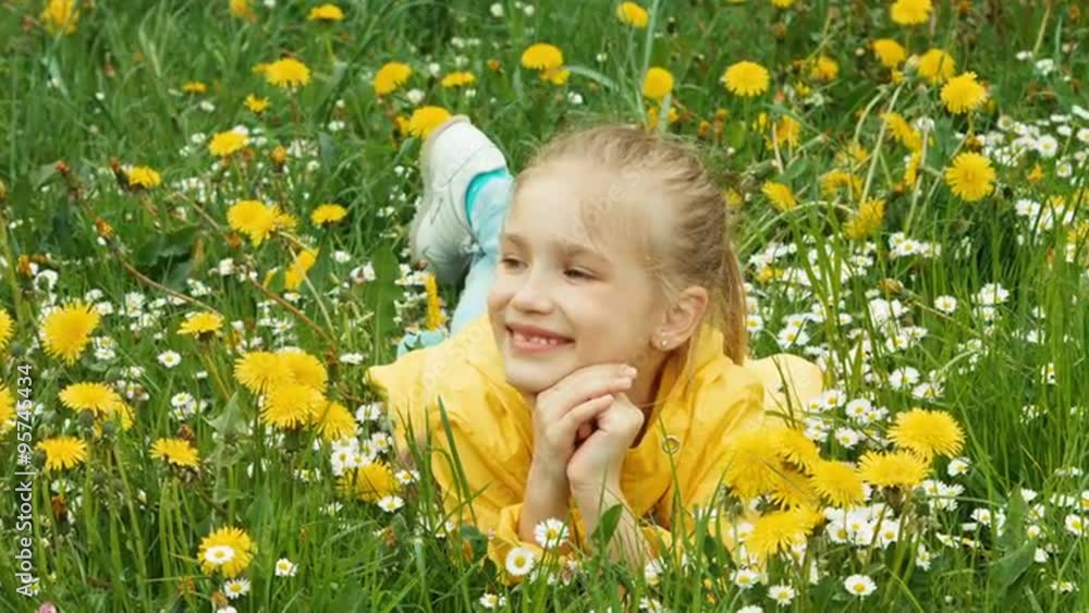 Laughing girl lying in the grass and looking at camera Laughing girl lying in the grass and looking at camera