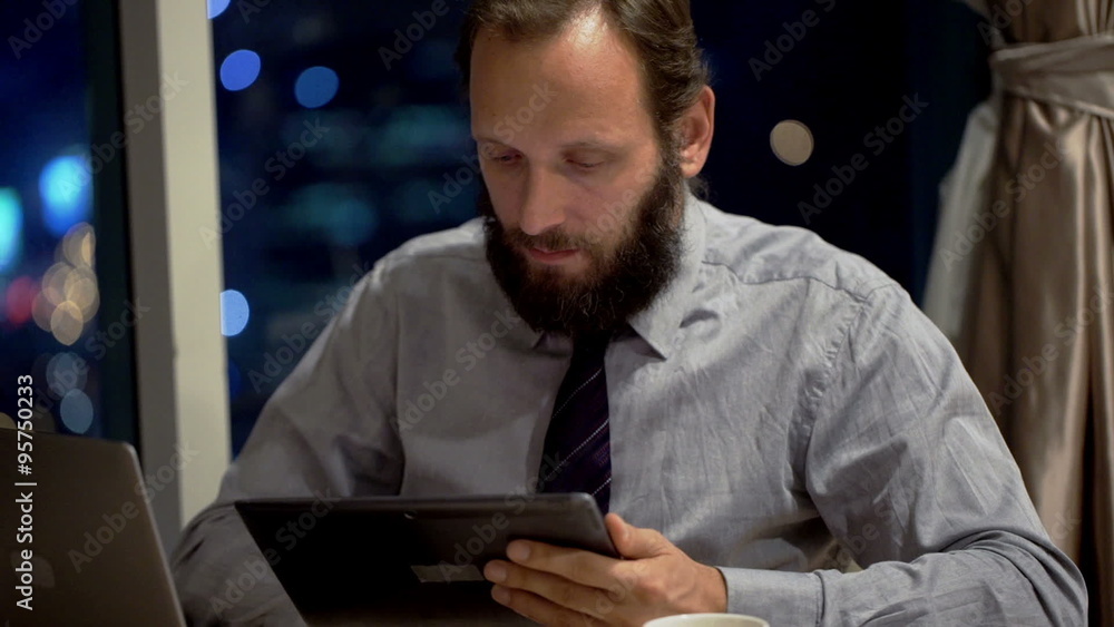 Young businessman using tablet computer by desk in office at night
Young businessman using tablet computer by desk in office at night