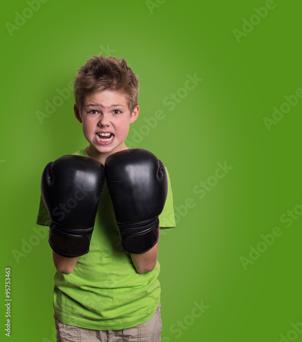 Portrait of a sporty angry boy engaged in boxing with copyspace.  © Polina Ponomareva
