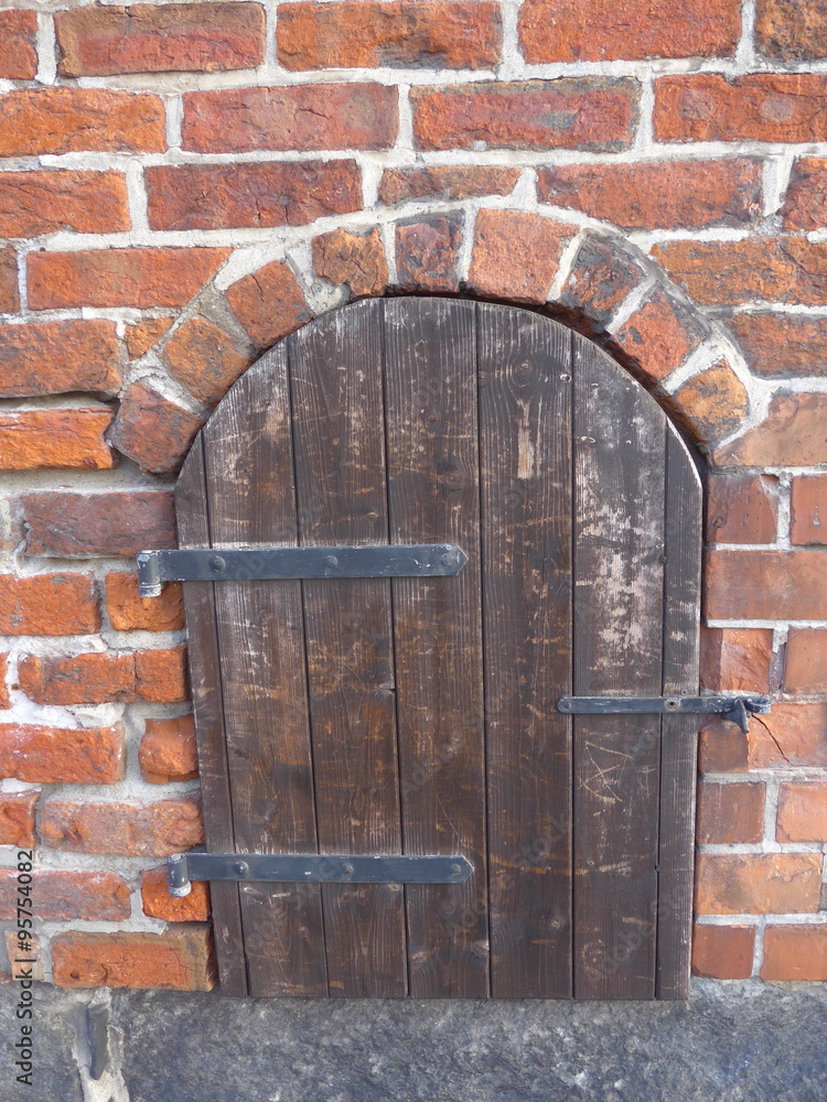 A weathered, closed wooden window in an old brick building, Bild A weathered, closed wooden window in an old brick building, Bild