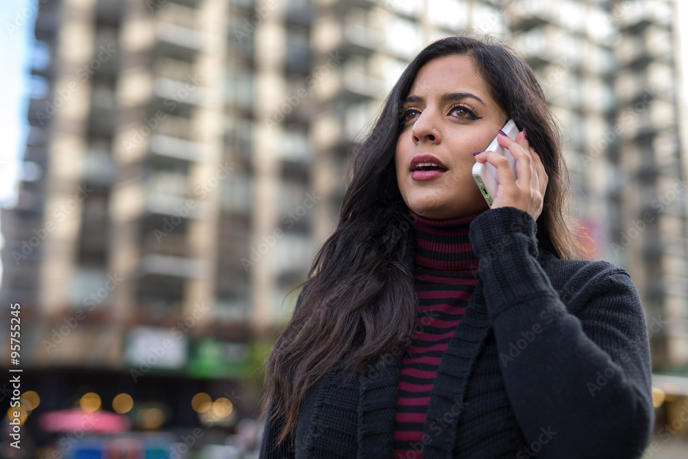 Indian woman in city talking on cell phone