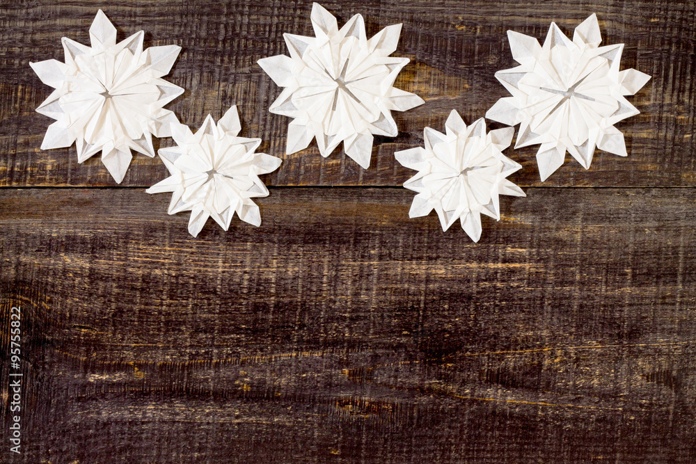 Postcard origami ornaments with snowflakes on a dark wooden back