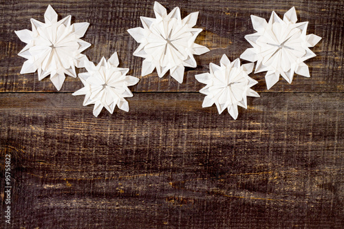 Postcard origami ornaments with snowflakes on a dark wooden back