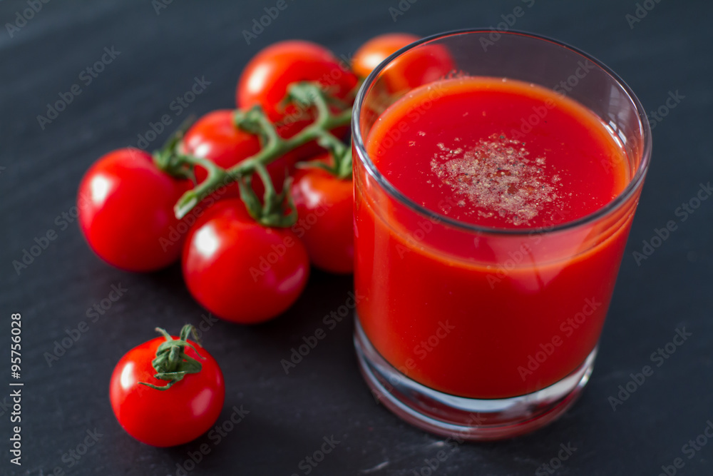 Tomato juice in glass, dark stone background Tomato juice in glass, dark stone background