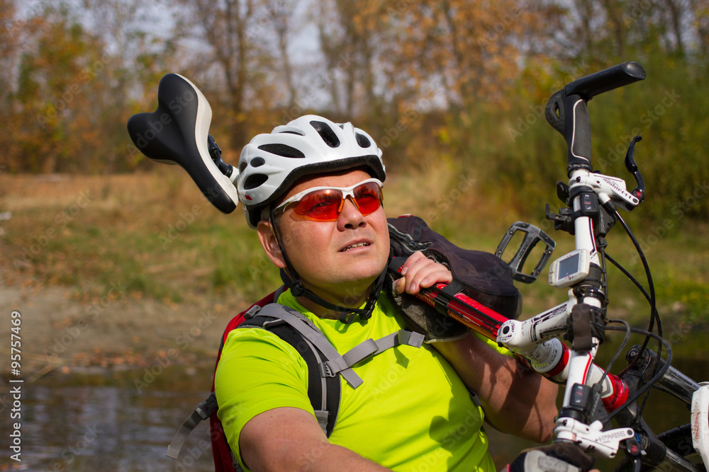 Young athlete crossing rocky terrain with bicycle in his hands. Young athlete crossing rocky terrain with bicycle in his hands.