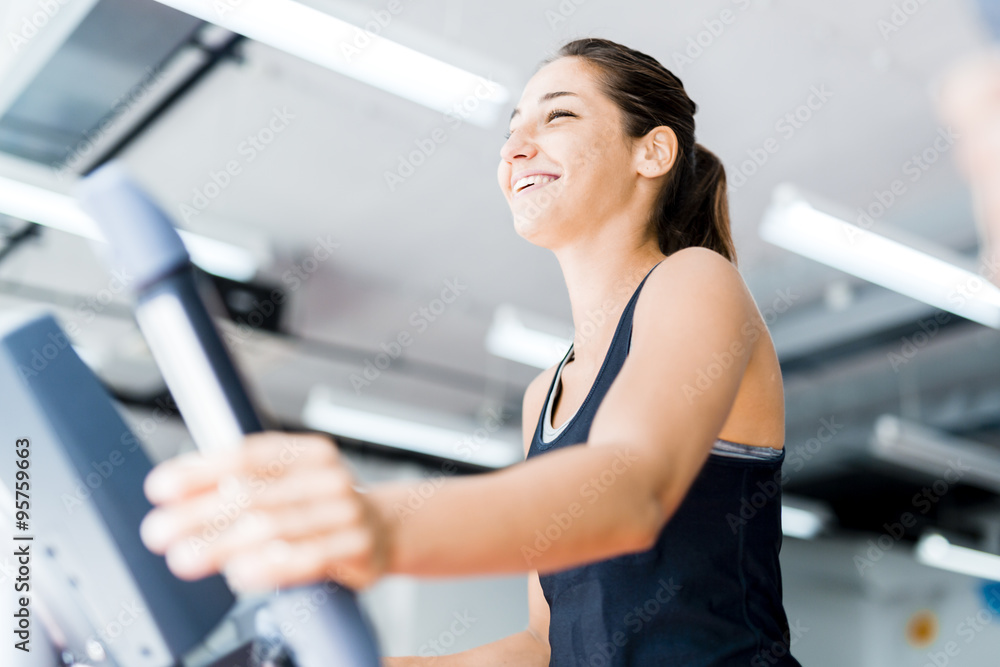 Beautiful young lady using the elliptical trainer Beautiful young lady using the elliptical trainer