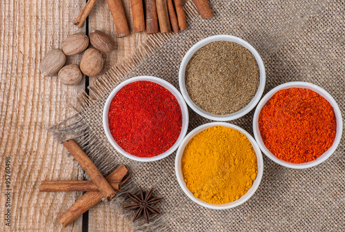 Spices in bowls on wooden background