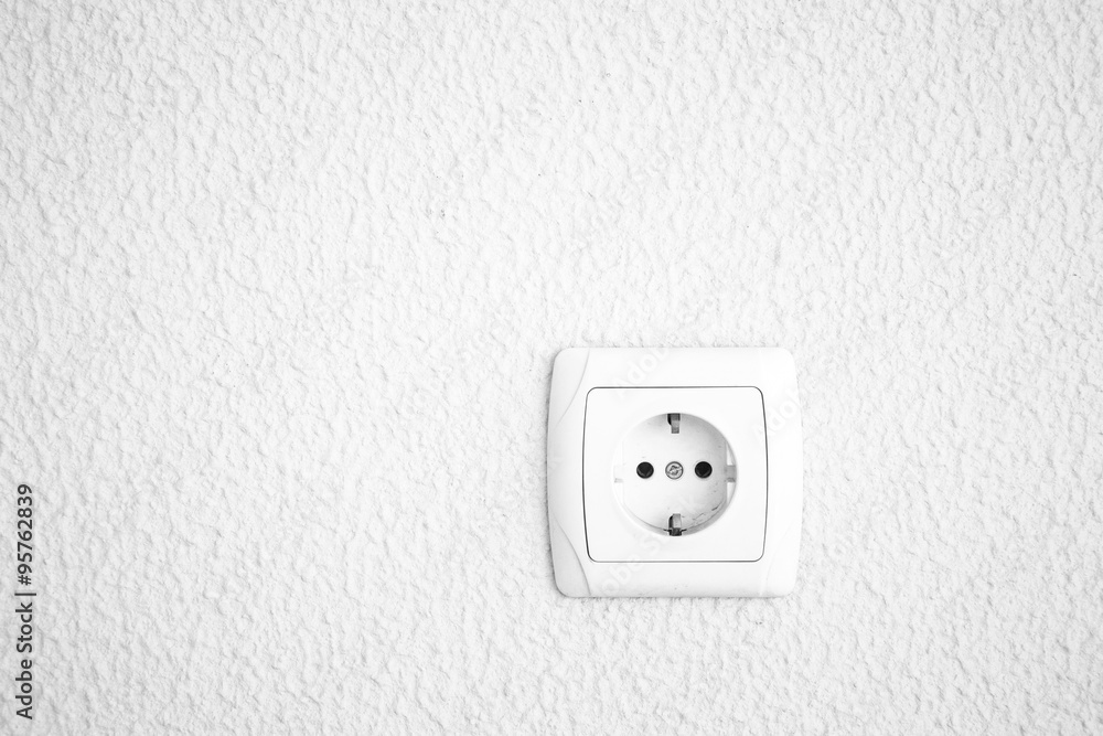 Light plastered wall with electric outlet for background. Close Light plastered wall with electric outlet for background. Close