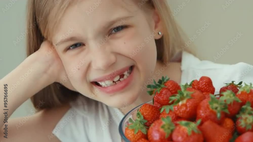 Extreme portrait girl hugging big plate of strawberries and laughing at camera. Top view Extreme portrait girl hugging big plate of strawberries and laughing at camera. Top view