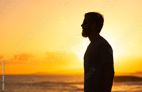 Young man is looking at the sunrise. 