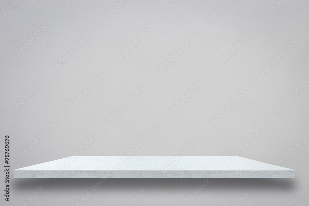 Empty top of white wooden shelf on grey cement wall