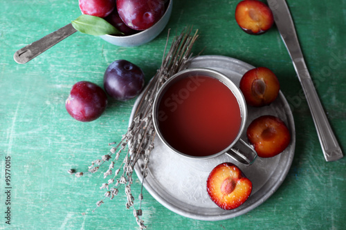 Delicious plum juice with fruits on wooden table close up