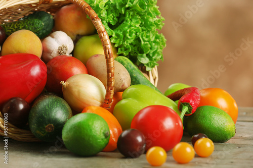 Fototapeta Naklejka Na Ścianę i Meble -  Heap of fresh fruits and vegetables in basket on wooden table close up