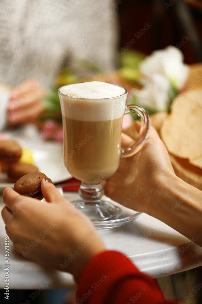 Woman holding cup of latte in cafe Woman holding cup of latte in cafe