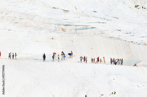 Pamukkale, Turkey - August, 14 2015: Tourists on Pamukkale Travertine pools and terraces. Pamukkale is famous UNESCO world heritage site in Turkey