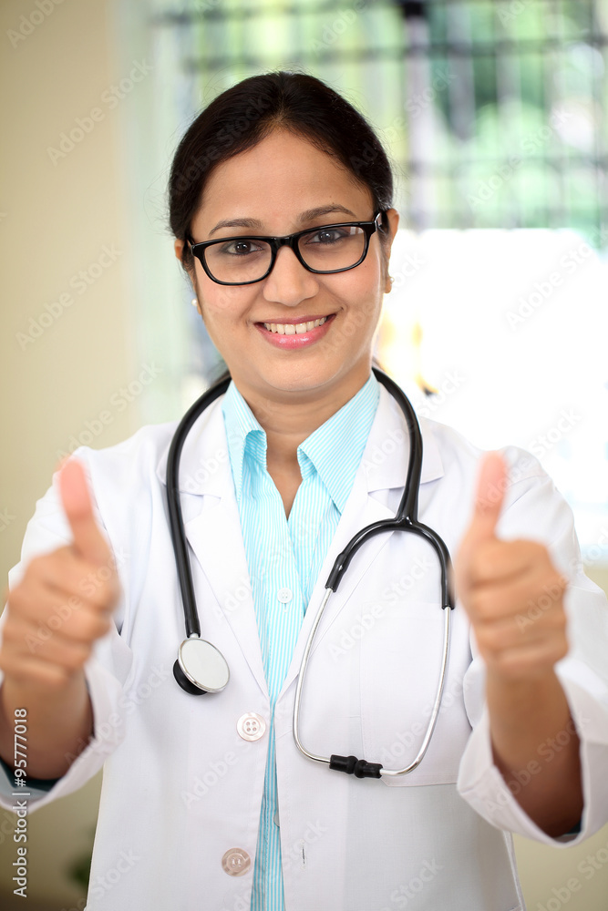 Young female doctor showing thumbs up gesture Young female doctor showing thumbs up gesture