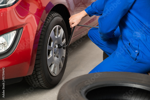 Mechanic Changing Tire In Garage
