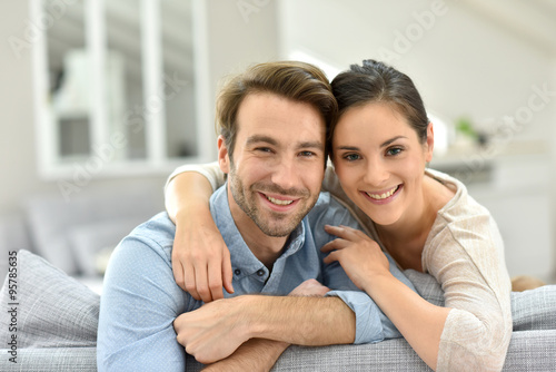 Portrait of couple sitting in sofa at home