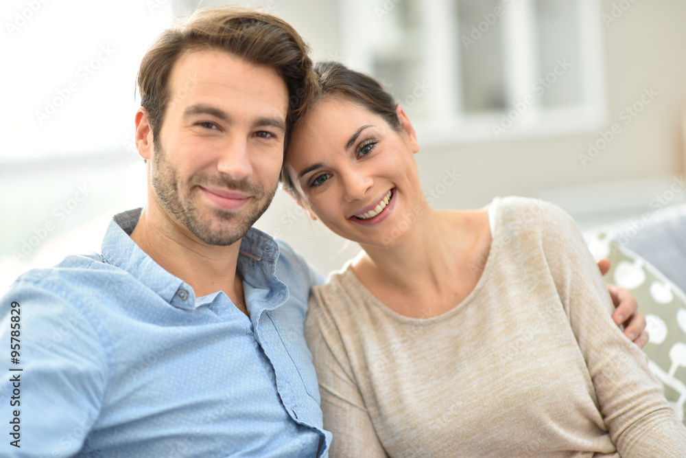 Young smiling couple sitting in sofa at home Young smiling couple sitting in sofa at home