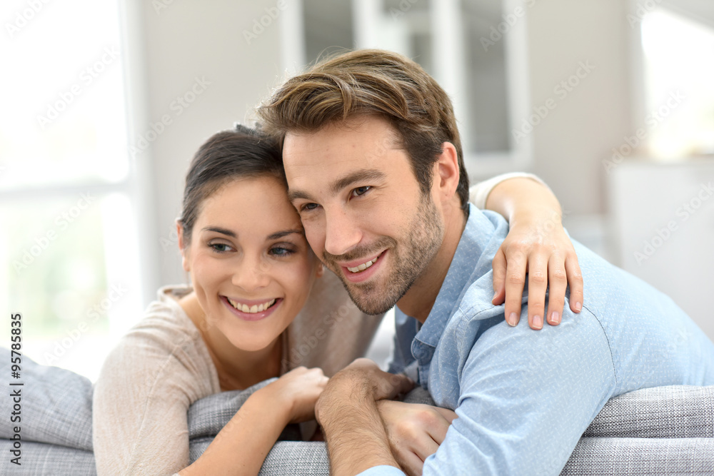 Portrait of couple sitting in sofa at home