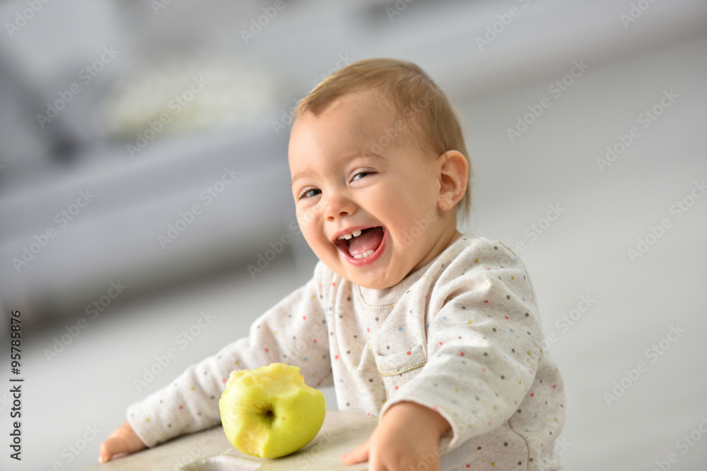 Cute 15-month-old baby girl eating an apple Cute 15-month-old baby girl eating an apple