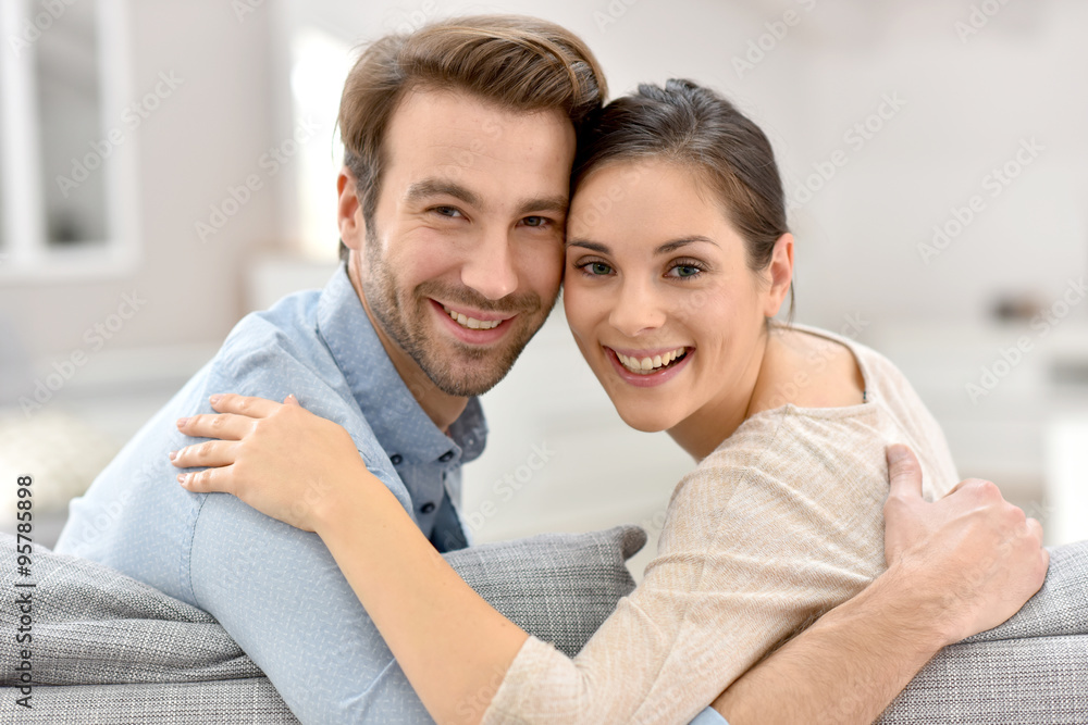 Portrait of couple sitting in sofa at home Portrait of couple sitting in sofa at home