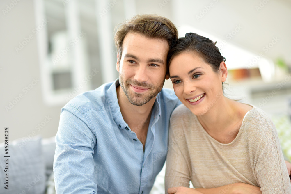Young smiling couple sitting in sofa at home Young smiling couple sitting in sofa at home