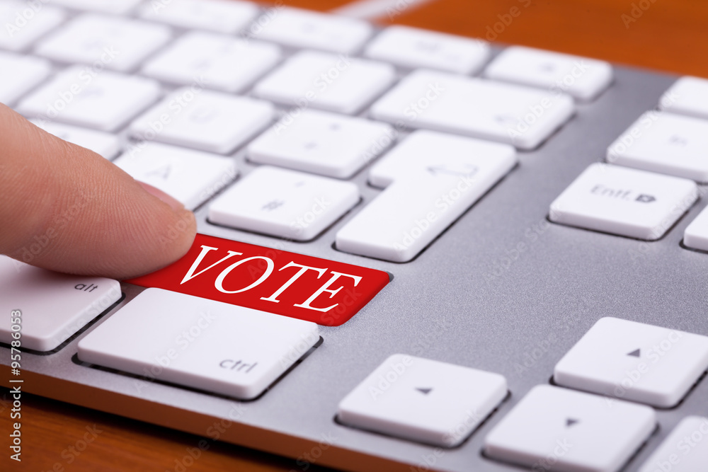 Finger pressing on vote red button on keyboard Finger pressing on vote red button on keyboard