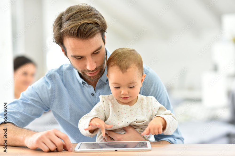 Man with baby looking at digital tablet Man with baby looking at digital tablet