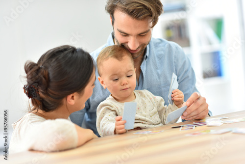 Parents with baby girl playing cards