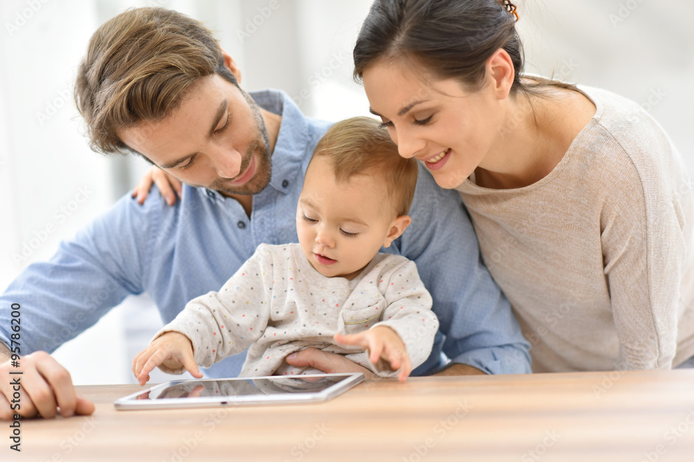Parents with baby girl playing with digital tablet Parents with baby girl playing with digital tablet