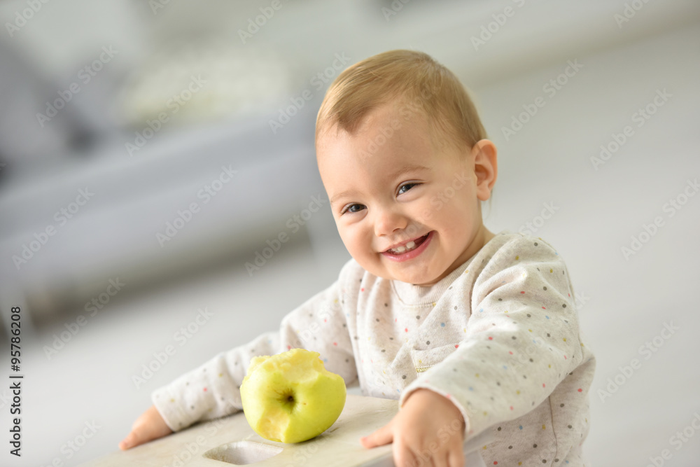 Cute 15-month-old baby girl eating an apple Cute 15-month-old baby girl eating an apple