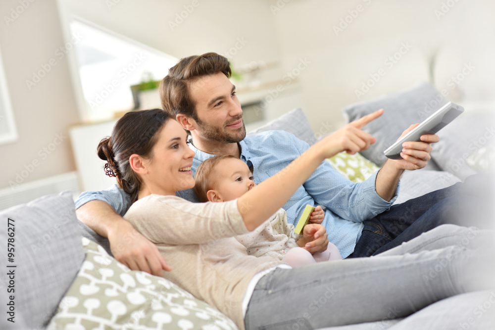 Family with baby in sofa watching tv Family with baby in sofa watching tv