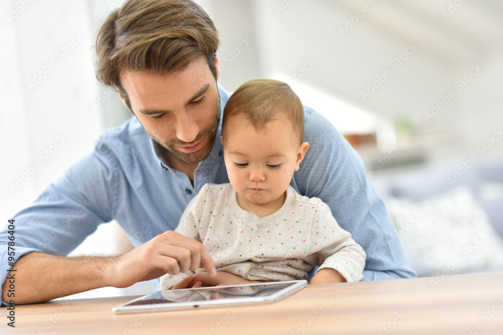 Man with baby looking at digital tablet Man with baby looking at digital tablet
