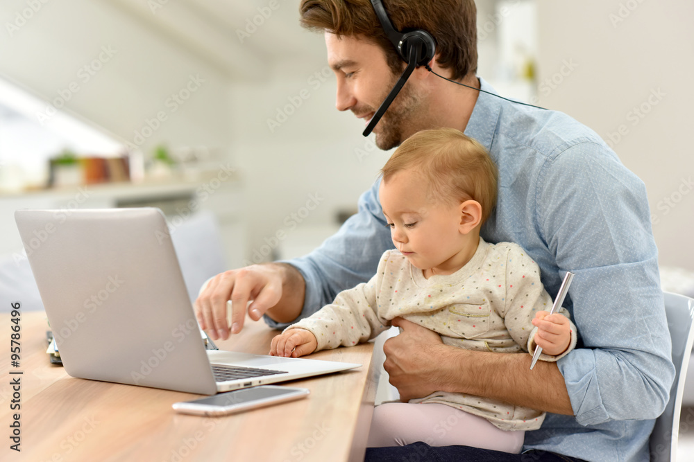 Busy businessman working from home and watching baby Busy businessman working from home and watching baby