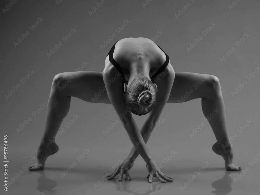 Obraz premium Modern ballet dancer posing on dark background