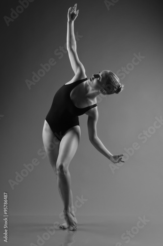 Fototapeta Naklejka Na Ścianę i Meble -  Modern ballet dancer posing on dark background