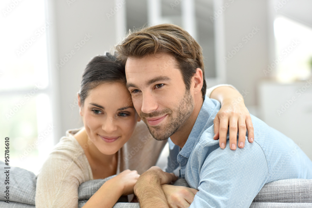 Portrait of couple sitting in sofa at home Portrait of couple sitting in sofa at home