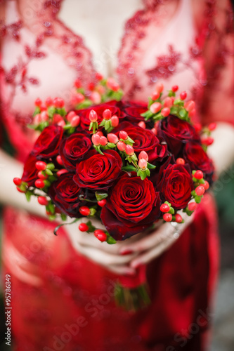 bride holding her red wedding bouquet of flowers