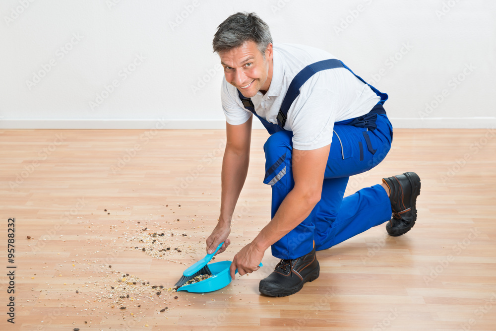 Janitor Sweeping Floor With Brush And Dustpan