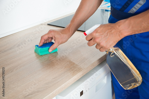 Male Janitor Cleaning Kitchen Counter