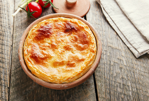 homemade pie with feta cheese and spinach in a clay bowl