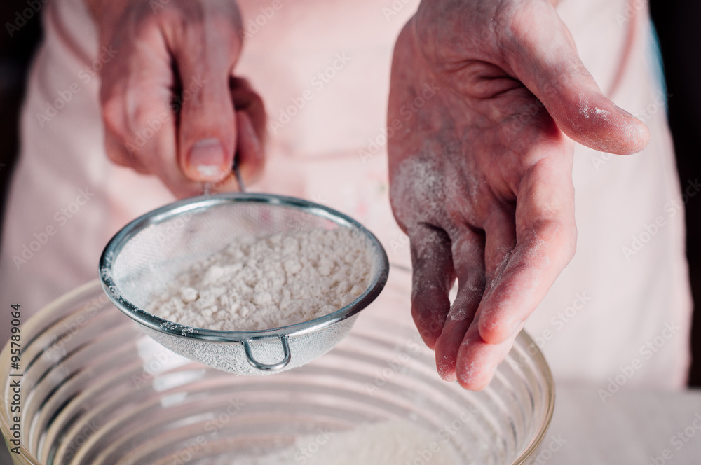 Man sifting flour for pizza dough