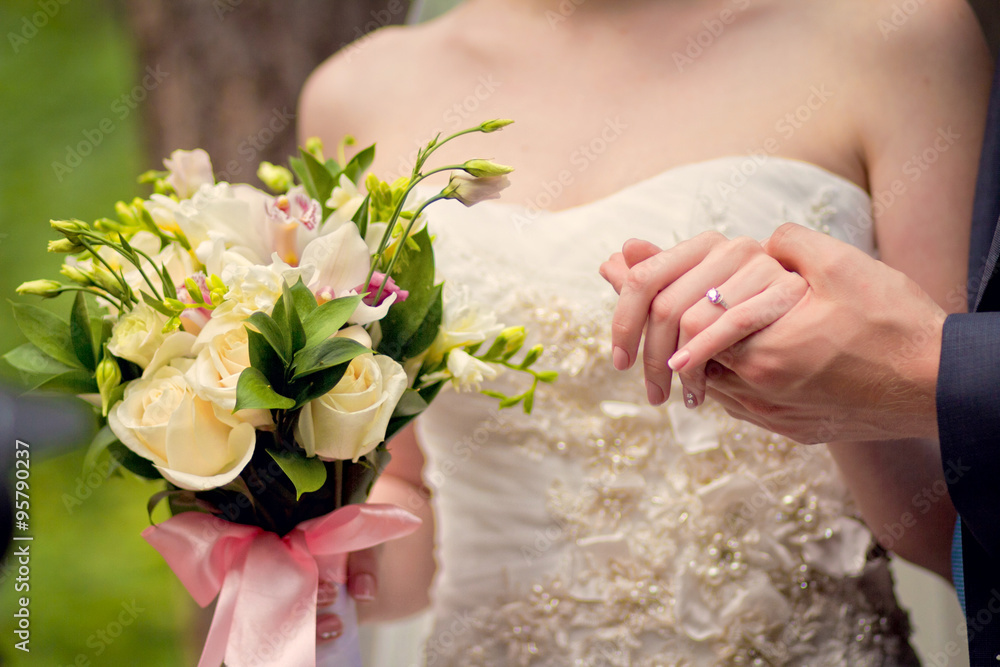 Hands of groom and bride on a wedding bouquet Hands of groom and bride on a wedding bouquet