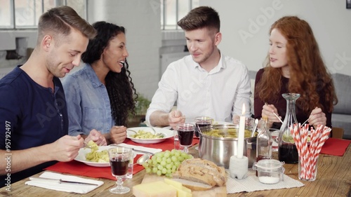 freunde sitzen in der wohnung am esstisch und unterhalten sich photo